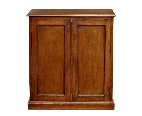 An early 20th century stained oak shoe cupboard, the moulded top over two cupboard doors enclosing interior with brass rails,