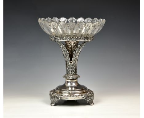 A late-Georgian silver plate and cut glass table centrepiece, the circular base with foliate border and foliate bracket feet,