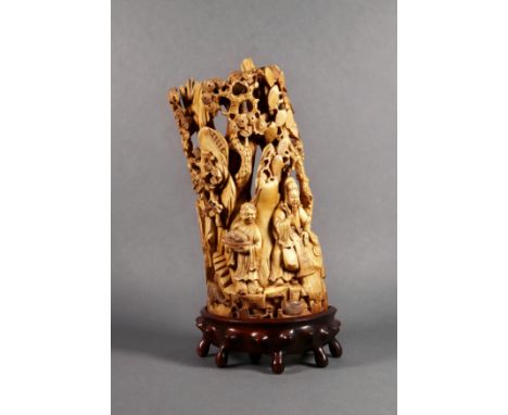 A Chinese ivory half-tusk carving, probably 18th century, Qing Dynasty, depicting a calligrapher and his attendant standing o