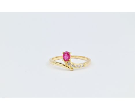 An 18ct gold, ruby and diamond ring, featuring an oval cut ruby measuring approximately 3.5x4.5mm and held vertically at the 