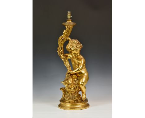 A gilt figural table lamp, late 20th century, modelled as a putto holding a foliate torch, seated upon a rococo style foliate