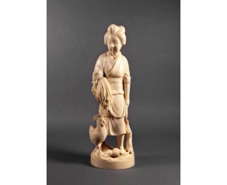 A Japanese carved ivory figure of a female peasant farmer, Meiji period (1868-1912), with a bundle of rice stalks under one a