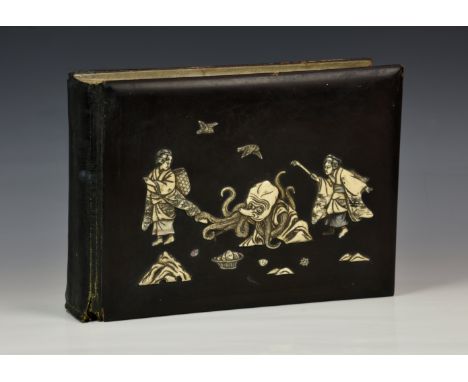 A Japanese lacquer photograph album, early 20th century, the cover with mother of pearl and carved bone inlay depicting figur