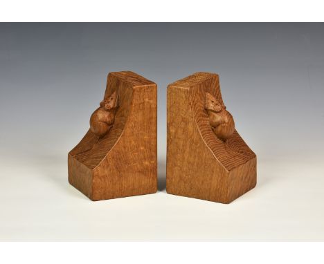 A pair of Robert Thompson of Kilburn 'Mouseman' adzed light oak bookends with carved mouse signature to each end, of typical 