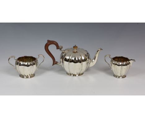 An elegant George VI silver three piece tea service, Wilson & Gill, Birmingham 1937, of melon form, comprising a teapot, milk