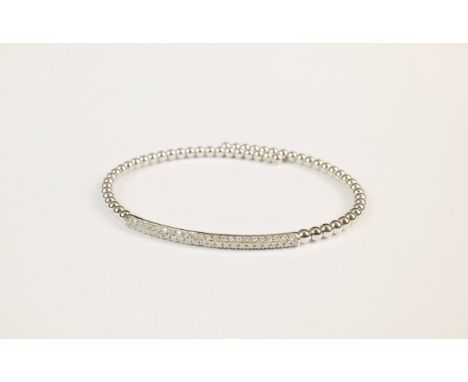 An 18ct white gold and diamond flexible bangle, featuring a pavé diamond studded panel atop a bubbled, white gold, flexible t