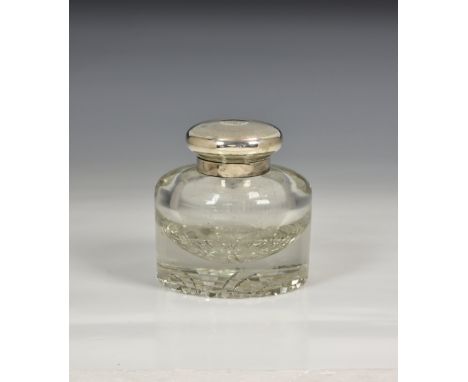 A large George V silver and glass inkwell, maker FH, London 1924, the hinged, engine turned silver cover with monogram, clear