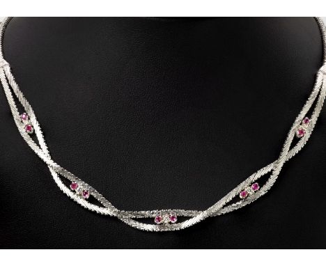 A 14ct white gold, ruby and diamond twist necklace, featuring a twisted articulated chain, looping around pairs of round cut 