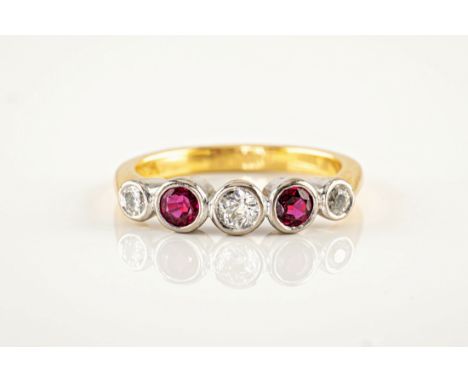 An 18ct gold, ruby and diamond 5 stone ring, featuring 3 brilliant cut diamonds and 2 round cut rubies held in rub over setti