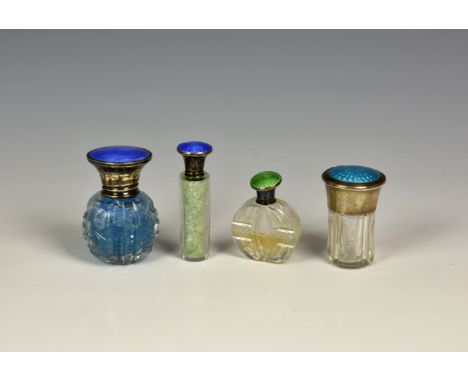 Four silver and enamel mounted cut glass scent bottles, with guilloche enamel decoration to the turn-off silver lids, two by 