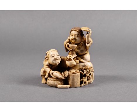 A Japanese carved ivory okimono of two fish vendors, Meiji period (1868-1912), one man crouches with a fish held above a bask