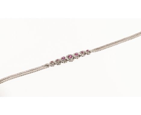 A 14ct white gold and ruby bracelet, featuring a braided articulated white gold strap, with knotted detailing to the centre a