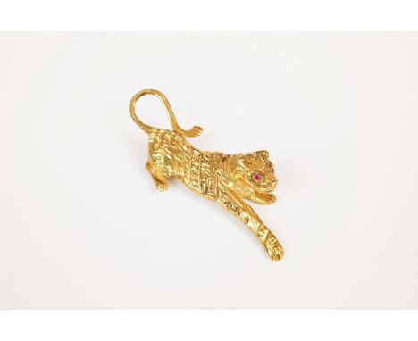 A 9ct yellow gold and ruby tiger brooch, the playful tiger with ruby set eyes, 53mm. long. 