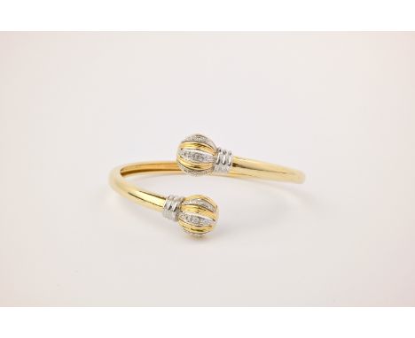 An 18ct gold and diamond torque bangle, the bangle of polished, yellow gold with with fluted, openwork brilliant cut diamond 