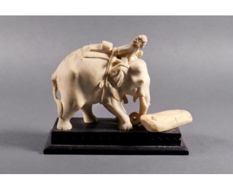 An Indian carved ivory figure of an elephant mahout, 19th century, the mahout astride the neck leans forward over the head to