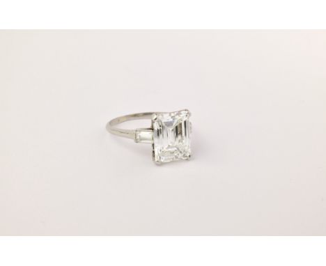 A fine and impressive platinum and diamond 3 stone ring, the central, emerald cut diamond weighing approximately 5.21ct and h