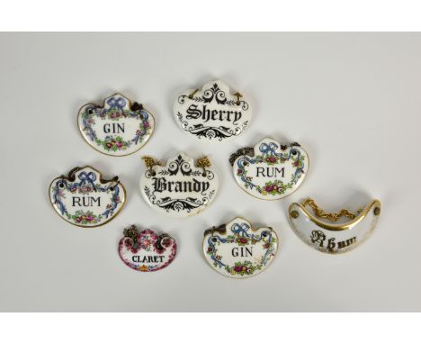 A small collection of eight bone china and enamel decanter labels, comprising 'BRANDY' and 'SHERRY' labels of shaped form by 