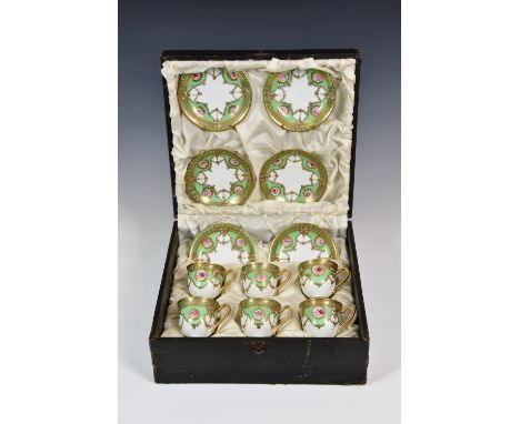 A cased set of six Continental porcelain demitasse cups and saucers, with ornate applied gilt decoration on apple green and w