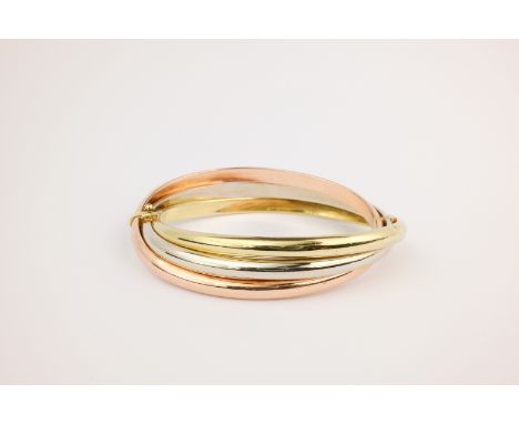 A 9ct gold tricoloured bangle, the hinged bangle formed of three twisted strands of yellow, white and rose gold. 