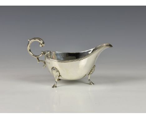 A George V silver sauce boat, William Hutton & Sons, Birmingham 1921, typical form with ribbed rim, leaf capped scroll handle