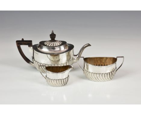 A Victorian silver three piece bachelor's tea set, Harrison Brothers, Sheffield 1880, oval form with part-fluted body, compri