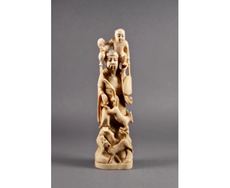 A Japanese carved ivory okimono of a deity, Meiji period (1868-1912), possibly Jurojin, standing on rocks with two hoofed ani