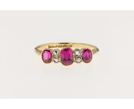 An 18ct gold, synthetic ruby and diamond 7 stone ring, featuring 3 graduated oval cut pink hued synthetic rubies with a pair 