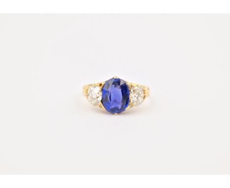 An antique 18ct gold, sapphire and diamond 3 stone ring, the central oval cut sapphire measuring approximately 10x8mm with an