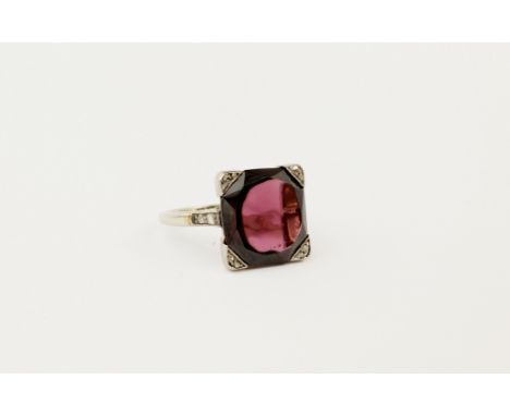 An 18ct white gold, garnet (possibly synthetic) and diamond ring, the garnet of deep, claret colouring and mixed square cut, 