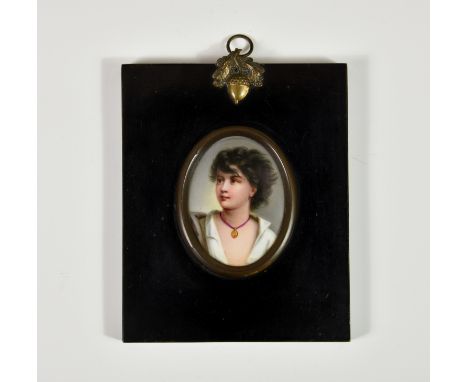 A porcelain portrait miniature of a young girl, late 19th century, oval, the young girl with black, windswept hair, open neck