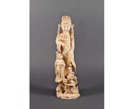 A Chinese carved ivory figure of a female deity, Qing Dynasty, wearing flowing robes, an elaborate headdress and holding a lo