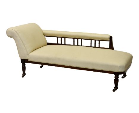 A late Victorian upholstered walnut chaise longue, with spindle back, over turned legs with ceramic castors, 68½ x 28in. (173