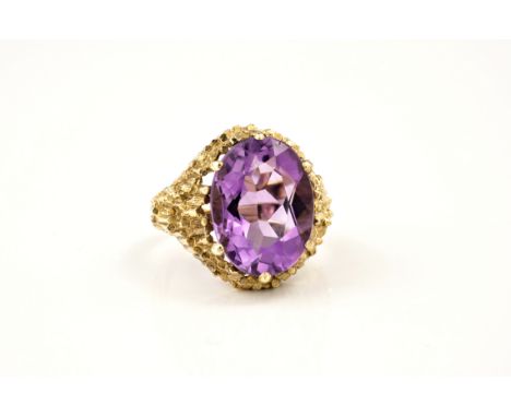 A modernist style 9ct gold and amethyst ring, hallmarked London 1971, the oval cut 15.5 x 12mm. amethyst in a bark effect set