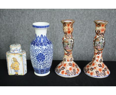 A Delft tea caddy, a Chinese blue and white vase and a pair of Imari candlesticks. H.23cm. (largest) 