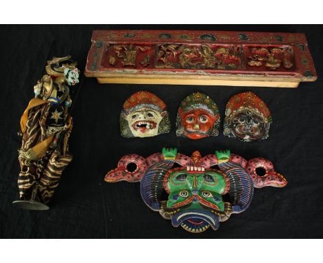 Four Balinese polychrome painted masks and a shadow puppet along with a carved and painted Chinese panel. H.50 W.13cm. (large