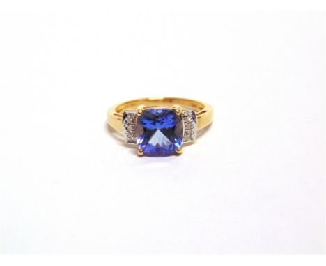 A 9 CARAT GOLD TANZANITE AND DIAMOND RING the cushion cut stone flanked by a trio of single cuts to each shoulder, finger M, 