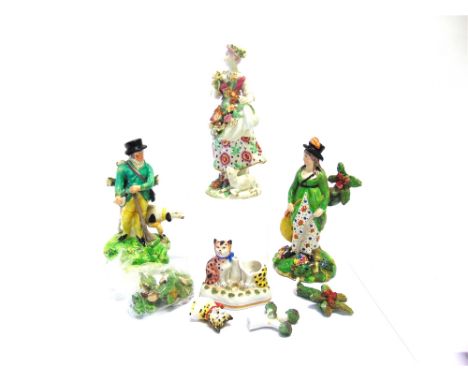 A PORCELAIN FIGURE OF A LADY  gathering flowers, a lamb seated at her feet, with polychrome enamel and gilt decoration, gold 