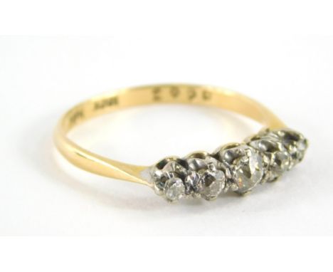 An 18ct gold and platinum diamond set dress ring, with five old cut diamonds each in claw setting, on raised baskets, ring si