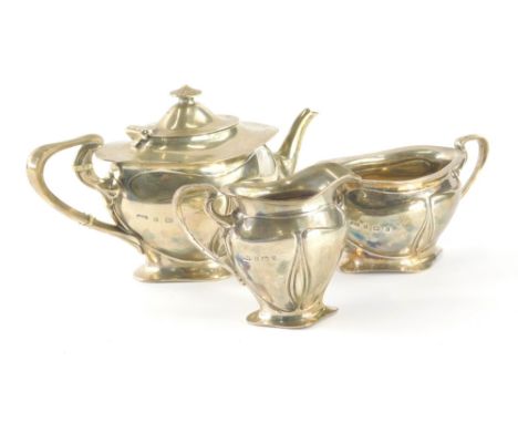 An Edwardian silver Art Nouveau three piece bachelors tea service, by Elkington and Co. comprising teapot of oval form with s