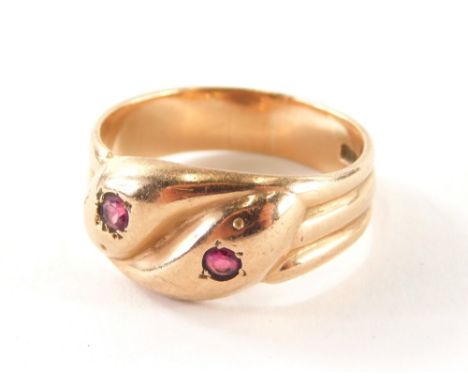 A 9ct gold dress ring, with two intertwined snakes heads, each set with ruby, on a three row rose gold band, ring size X½, 7g