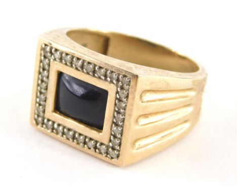 A 9ct gold gents signet ring, with central black stone set panel, surrounded by tiny diamonds, with reeded shoulders, ring si