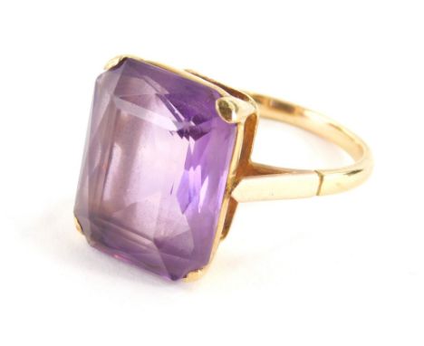 An amethyst dress ring, with central rectangular cut amethyst 18mm x 15mm, in a raised four claw mount, with pierced shoulder