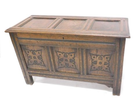 An 18thC oak three panel coffer, the plain top hinged to reveal a plain interior with a carved panel front on stiles, initial