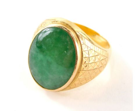 A Chinese jade signet ring, the large oval jade centre 20mm x 15mm, in a rub over setting, with hatch design shoulders, on a 