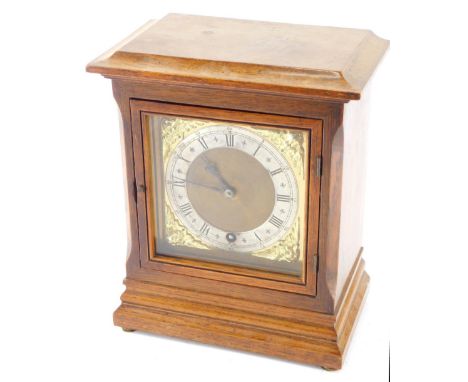 An early 20thC oak cased mantel clock, 12cm wide back plate with raised spandrels and silvered chapter ring with Roman numera