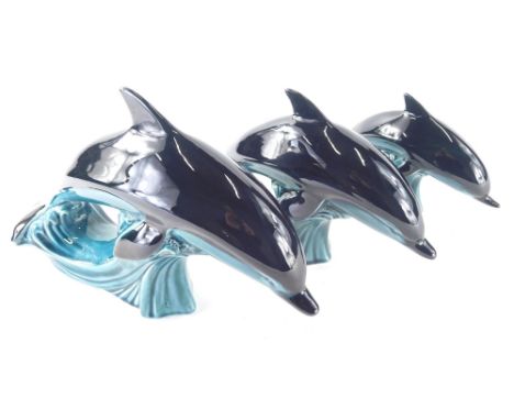 A graduated set of Poole dolphins, in black and turquoise colourway, 9cm high, printed marks beneath, etc. (3)