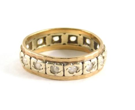 A diamond set eternity ring, with central tiny diamond in illusion white gold setting, with outer yellow metal beaded band, y