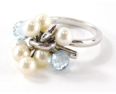 An 18ct white gold pearl diamond and blue topaz set dress ring, with cluster design of two pale blue topaz, and six pearls wi