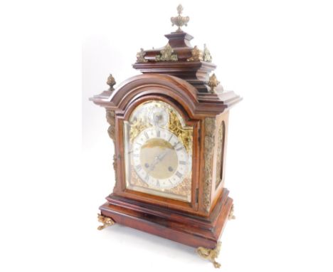 A late 19thC German rosewood mantel clock, with gilt metal mounts, the domed top embellished with flame finials, etc., above 