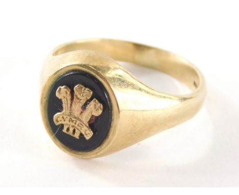 A 9ct gold gents signet ring, with black agate panel and raised fleur de lis, marked CYMRU, ring size W½, 5.3g all in.